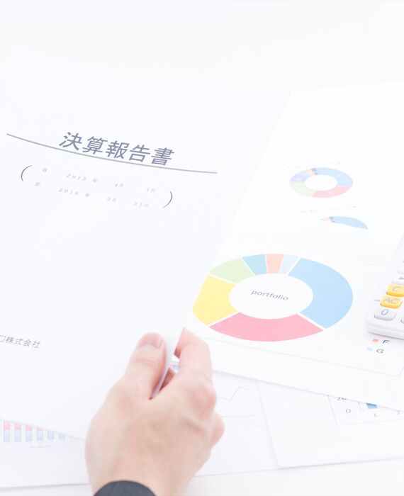 決算報告書を持つスタッフ